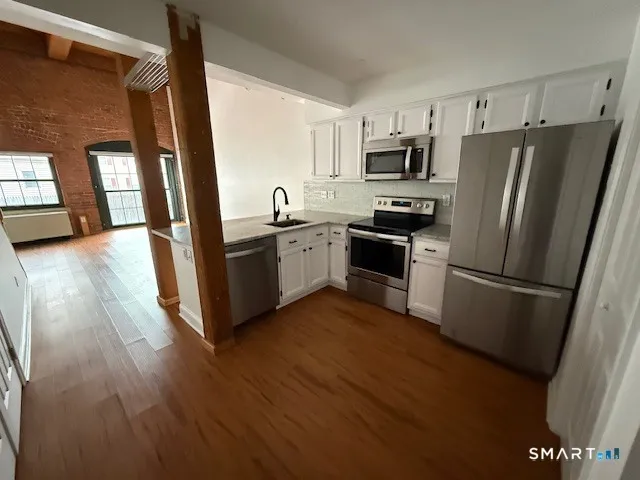 a kitchen with stainless steel appliances a refrigerator sink and microwave