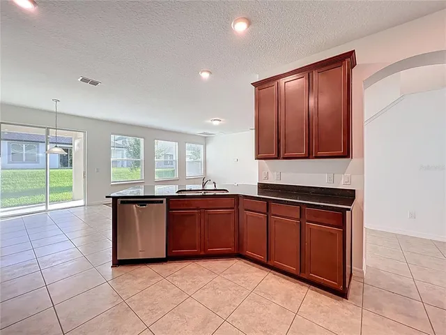 a large kitchen with granite countertop a sink and cabinets