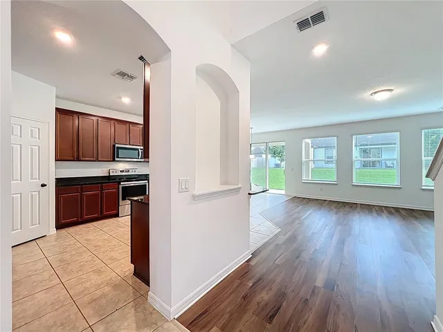 a kitchen with kitchen island wooden floors appliances and cabinets