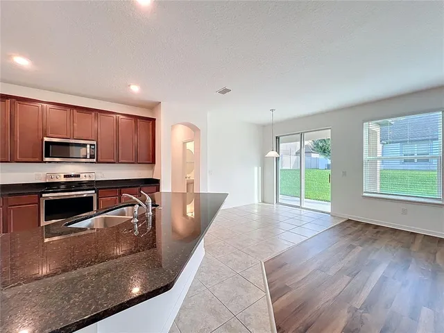 a kitchen with granite countertop a stove a sink and a microwave