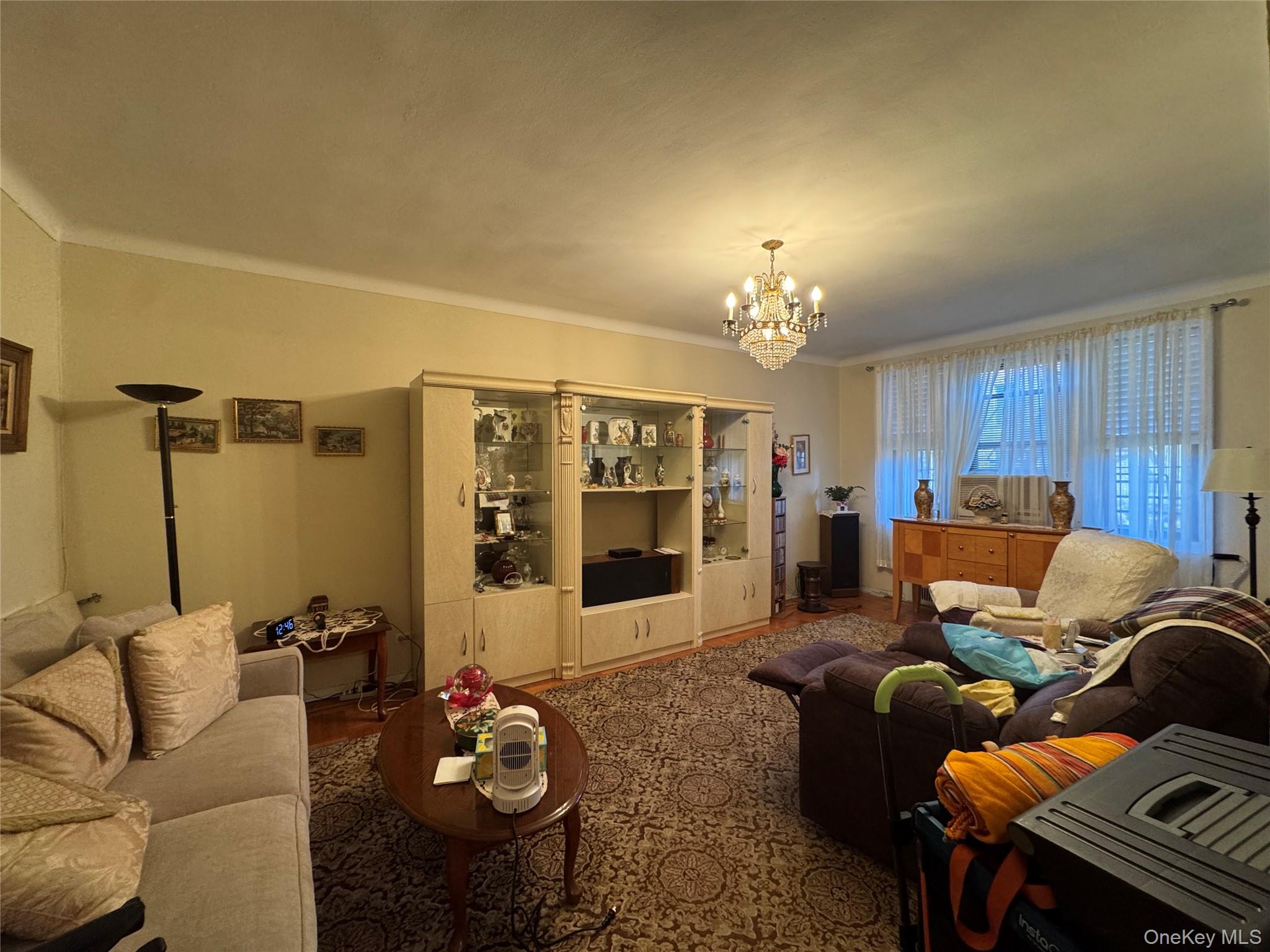 43-30 44th Street, Unit 3F Queens, NY 11104 - Photo 8 of 11 a living room with furniture and a chandelier