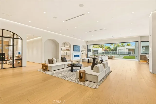 a large dining hall with stainless steel appliances kitchen island granite countertop a table and chairs in it