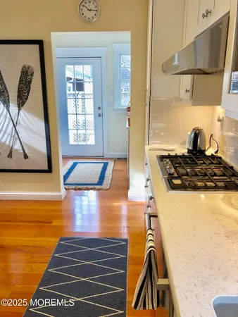 a kitchen with a stove and a wooden floor