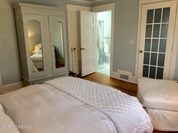 a bedroom with a bed and a large mirror