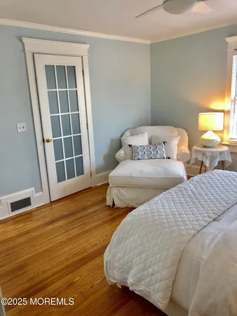 a bedroom with two beds and wooden floor