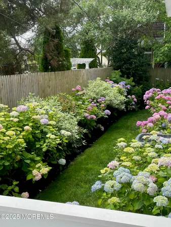 a garden with flowers and wooden fence