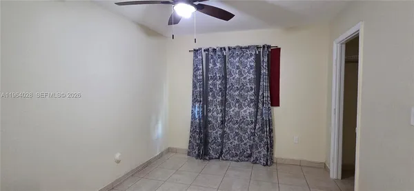 an empty room with a window and a fan