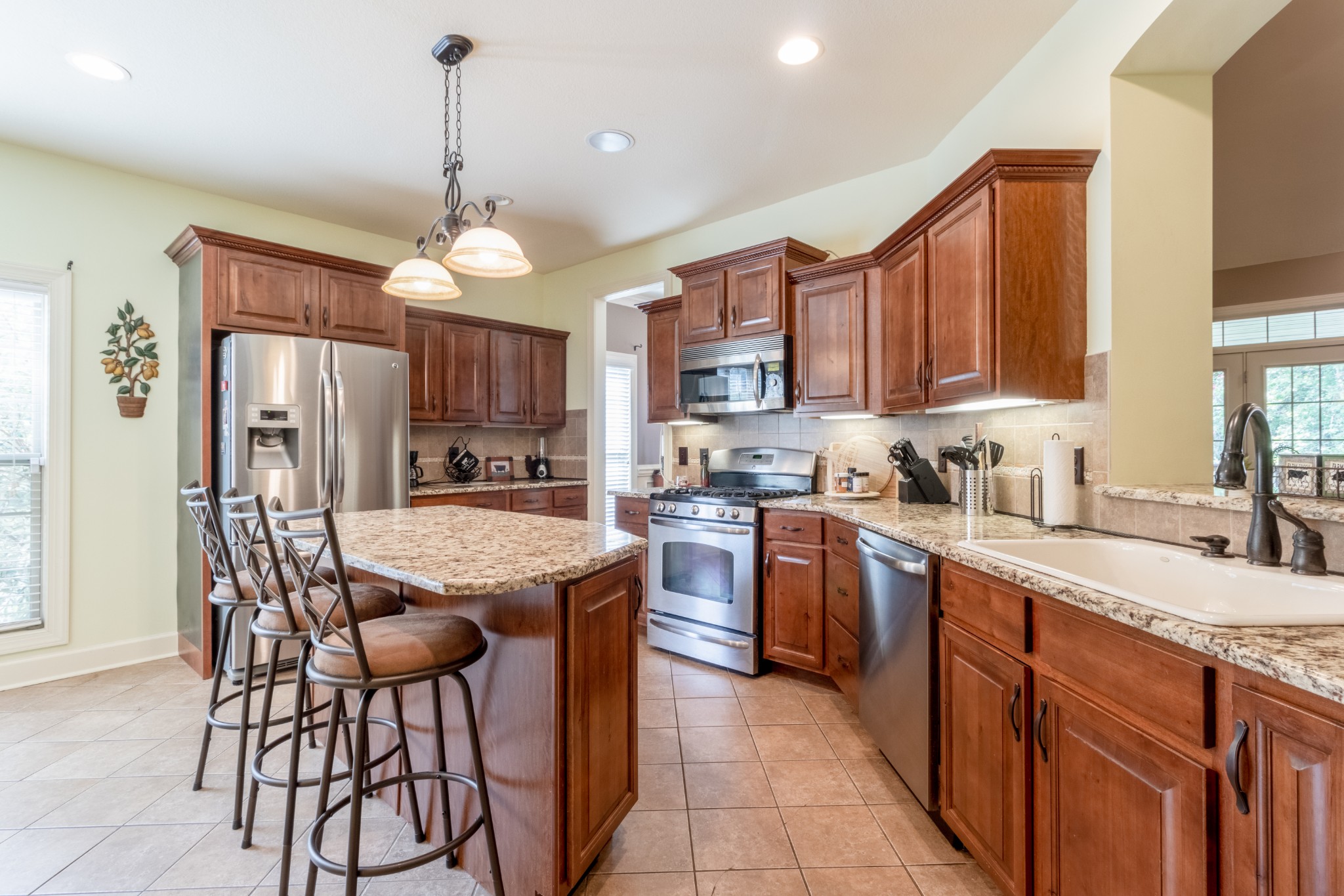 3592 Drake Road Adams, TN 37010 - Photo 14 of 47 a kitchen with stainless steel appliances granite countertop wooden cabinets a stove a sink and a refrigerator