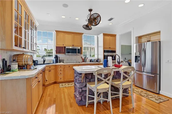 a kitchen with stainless steel appliances granite countertop a sink a stove and a refrigerator