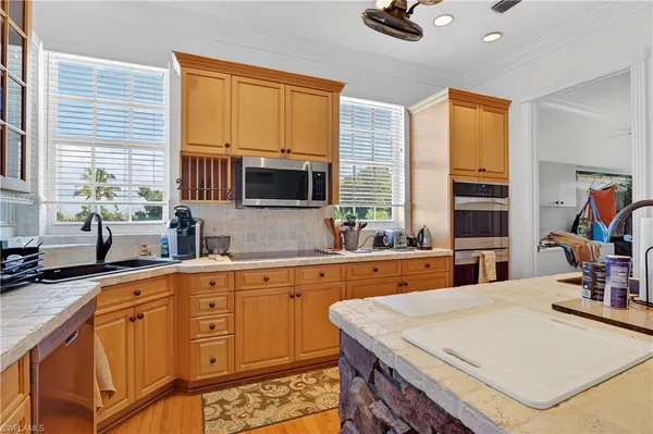a kitchen with stainless steel appliances granite countertop a sink a stove and cabinets