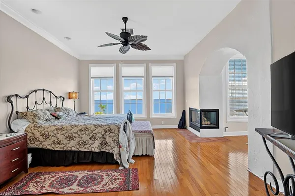 a bedroom with a bed a flat screen tv and windows