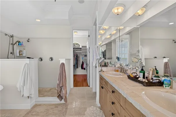 a large bathroom with a double vanity sink a mirror and a shower