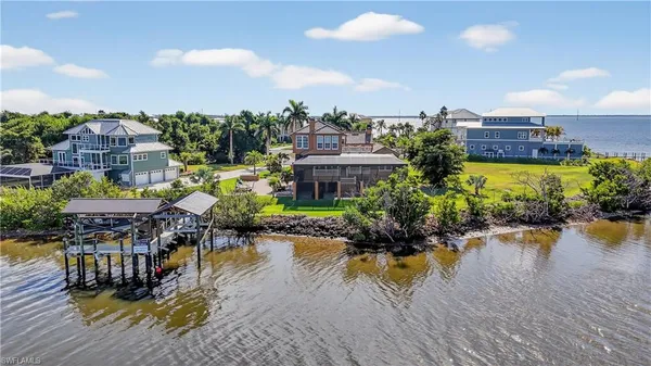a view of a lake with a house swimming pool and outdoor seating