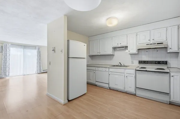 a kitchen with granite countertop white cabinets and white appliances