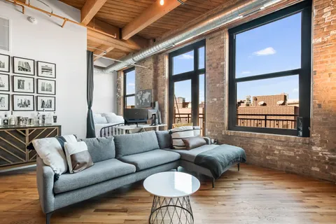 a living room with furniture and a floor to ceiling window
