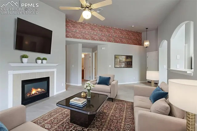 a living room with furniture a flat screen tv and a fireplace