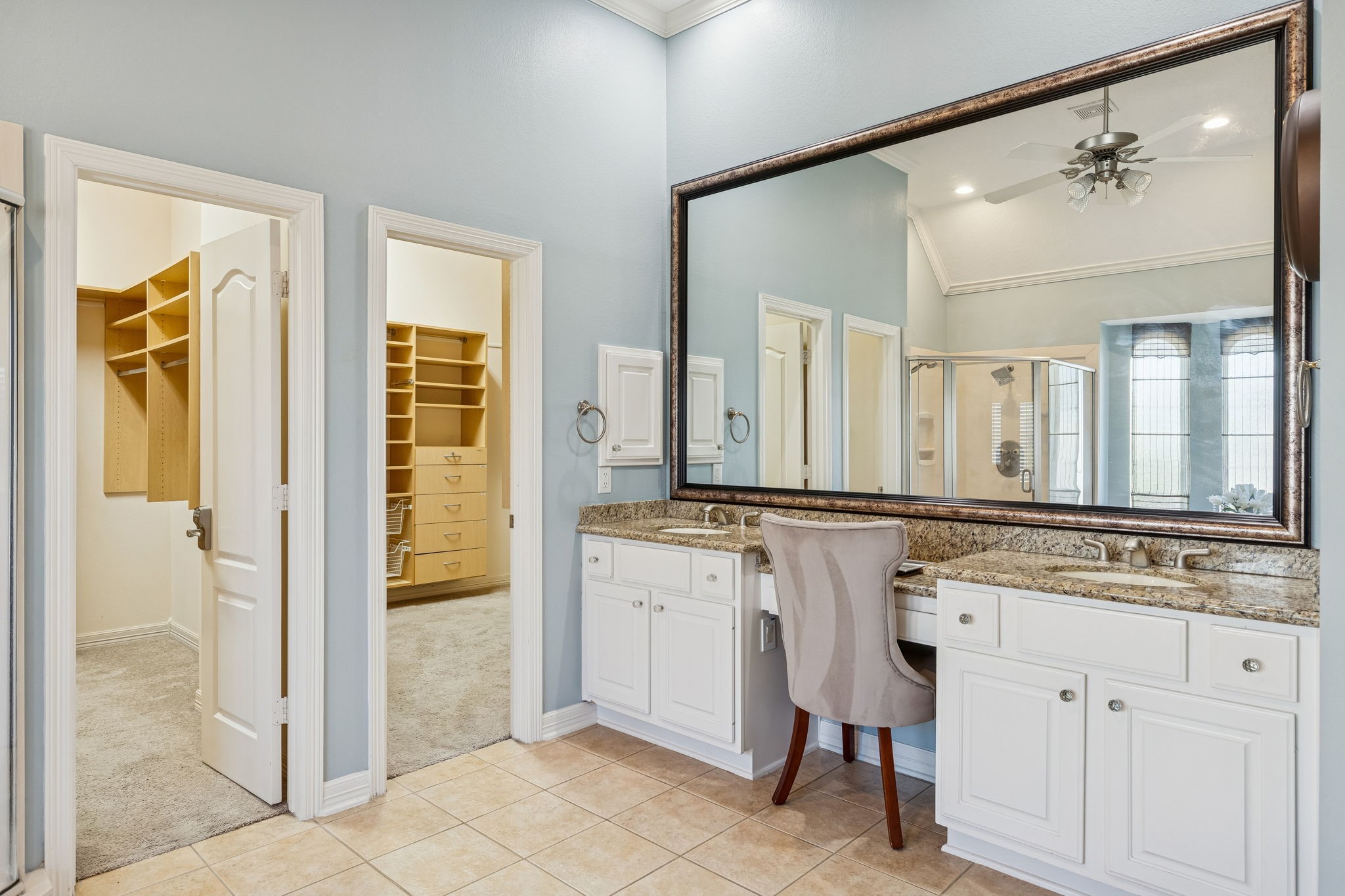 2202 Britton Ridge Drive Katy, TX 77494 - Photo 14 of 41 This primary bathroom features dual white vanities with granite counters, a built-in makeup station and a massive framed mirror that anchors the space.