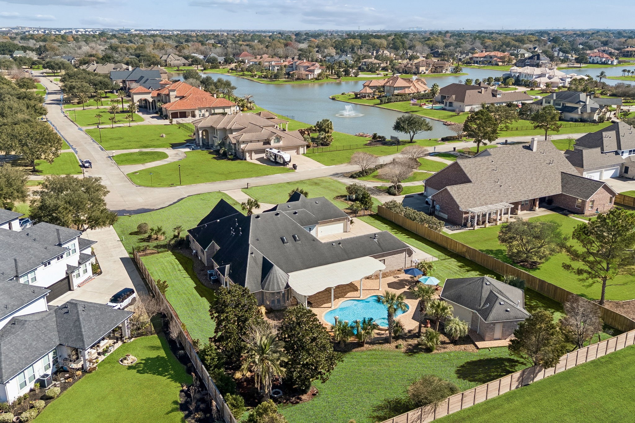 2202 Britton Ridge Drive Katy, TX 77494 - Photo 4 of 41 Elevated aerial perspective showcasing the home’s impressive scale and privacy within Lake Pointe Estates—highlighting the expansive lot, resort-style pool and cabana, and close proximity to the community lake, all tucked inside a quiet, guard-gated enclave.