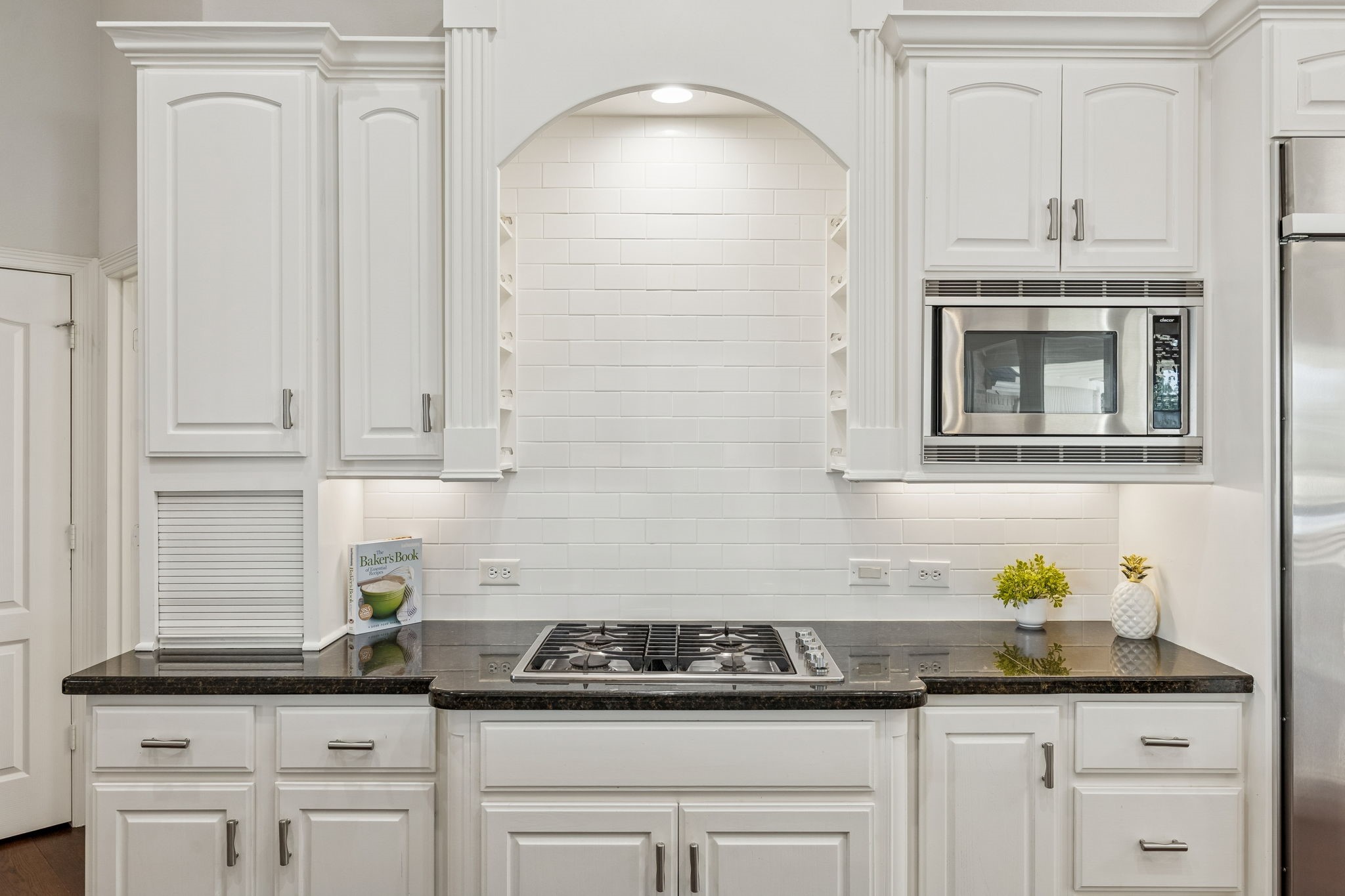 2202 Britton Ridge Drive Katy, TX 77494 - Photo 9 of 41 This beautiful cooking station features a sleek gas cooktop. Bright under-cabinet lighting beautifully illuminates the dark granite counters and custom white cabinetry.
