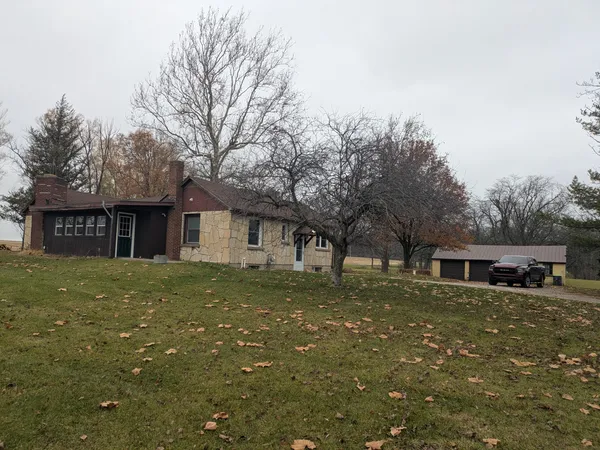 a view of a yard in front of a house with large tree