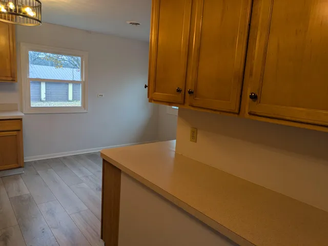 a utility room with wooden floor and cabinet