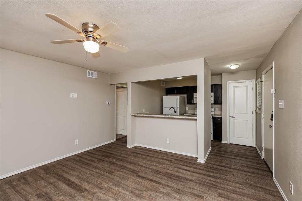 4622 Monarch Street, Unit 202 Dallas, TX 75204 - Photo 6 of 16 Open-concept living area featuring wood-finish flooring, a ceiling fan with integrated lighting, and neutral wall tones