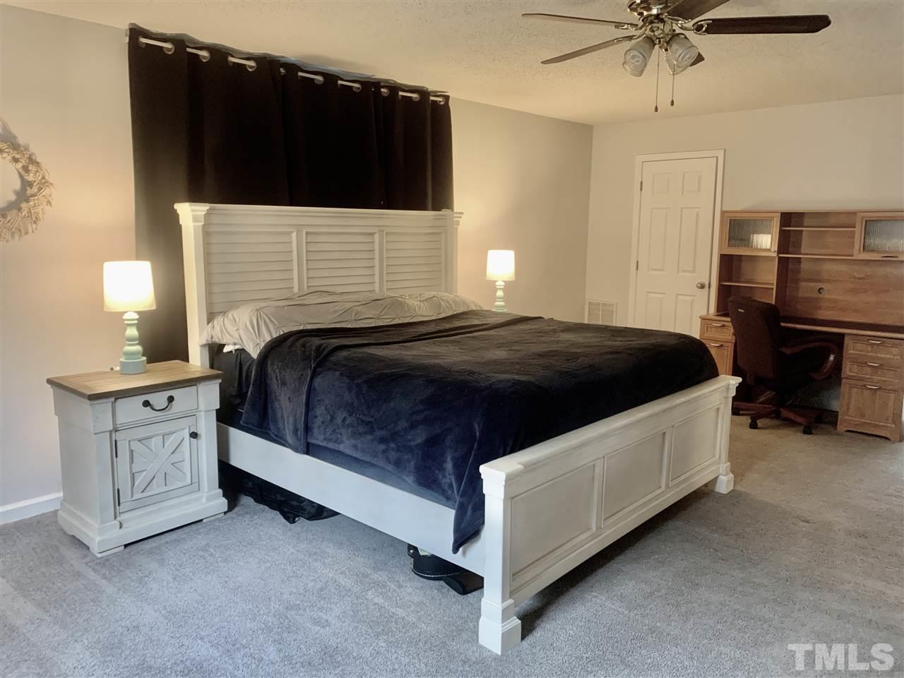816 Patrick Road Bahama, NC 27503 - Photo 16 of 20 a spacious bedroom with a bed and a ceiling fan
