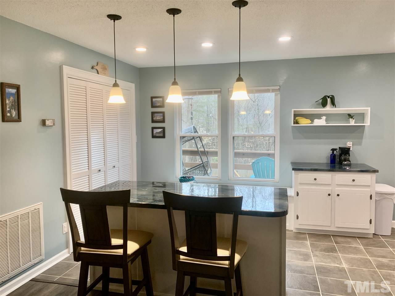 816 Patrick Road Bahama, NC 27503 - Photo 4 of 20 a kitchen with stainless steel appliances granite countertop a sink a stove a refrigerator a dining table and chairs