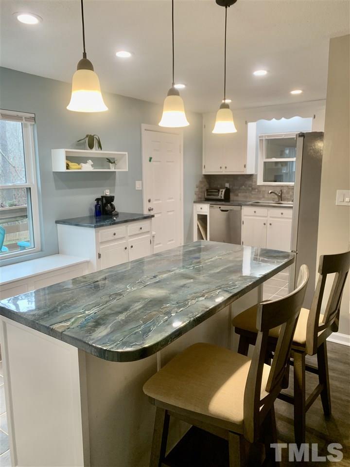 816 Patrick Road Bahama, NC 27503 - Photo 5 of 20 a kitchen with stainless steel appliances granite countertop a stove a sink a kitchen island a table and chairs