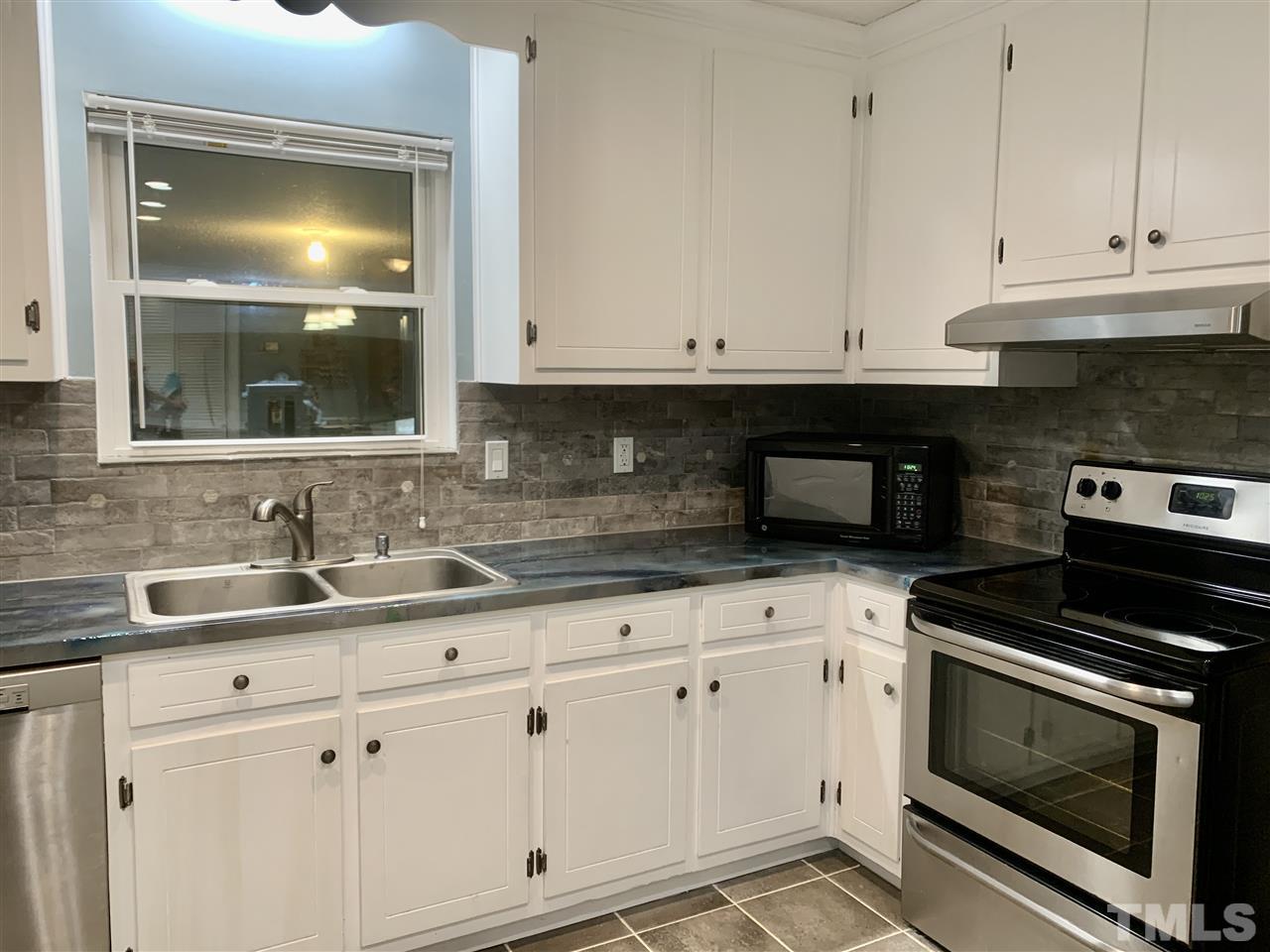 816 Patrick Road Bahama, NC 27503 - Photo 6 of 20 a kitchen with granite countertop white cabinets and appliances