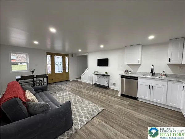 a living room with furniture flat screen tv and window