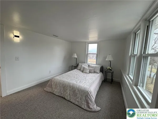 a bedroom with a bed and a large window