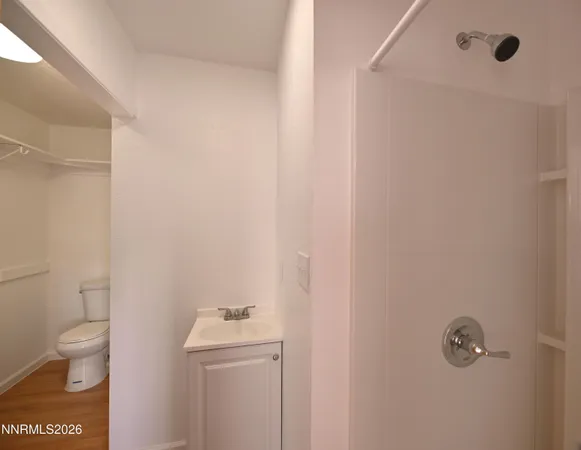 a bathroom with a toilet a sink a shower and mirror