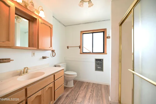 a bathroom with a sink a toilet and a window