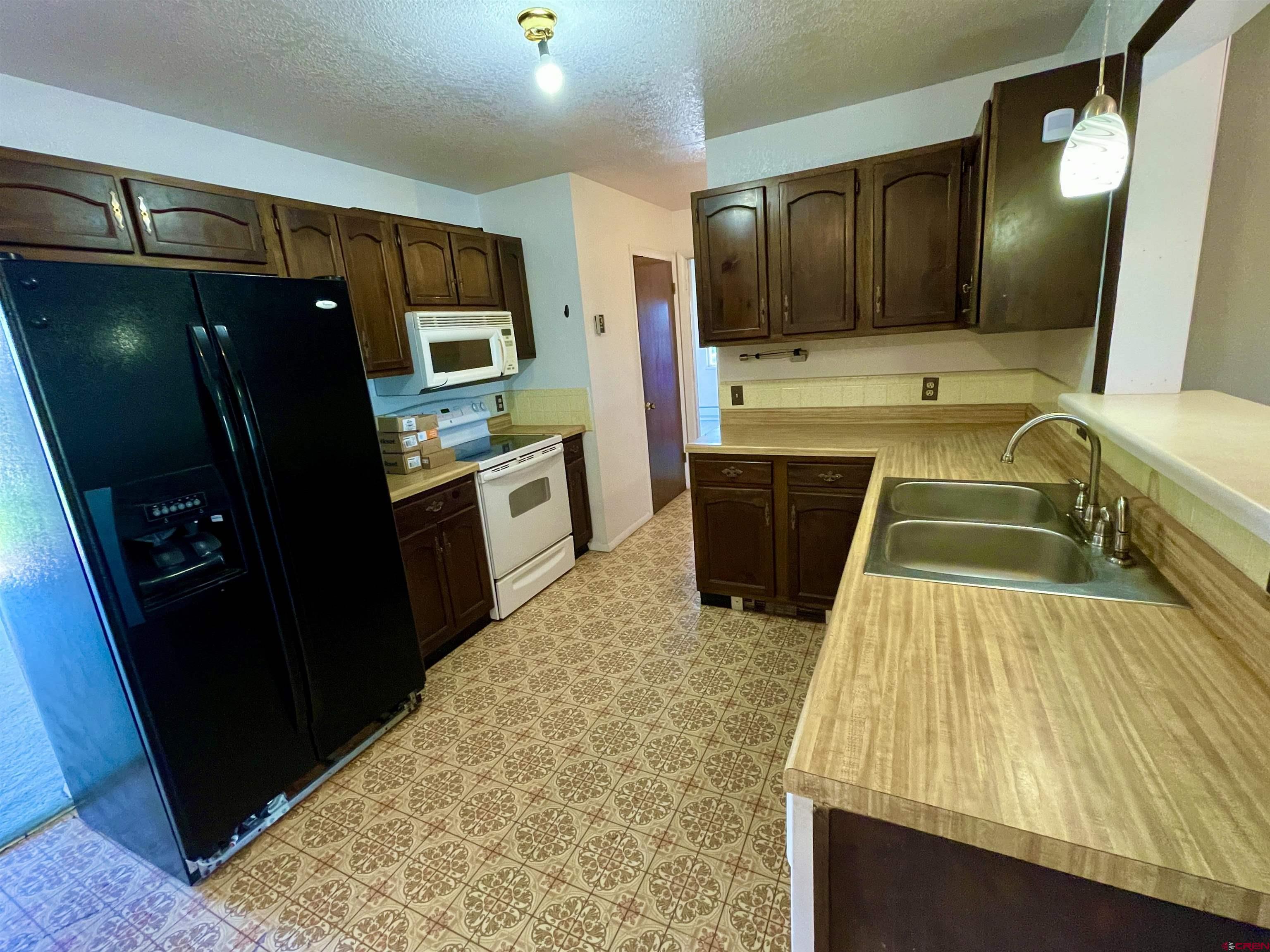 1733 B F Road Delta, CO 81416 - Photo 13 of 24 a kitchen with refrigerator and window