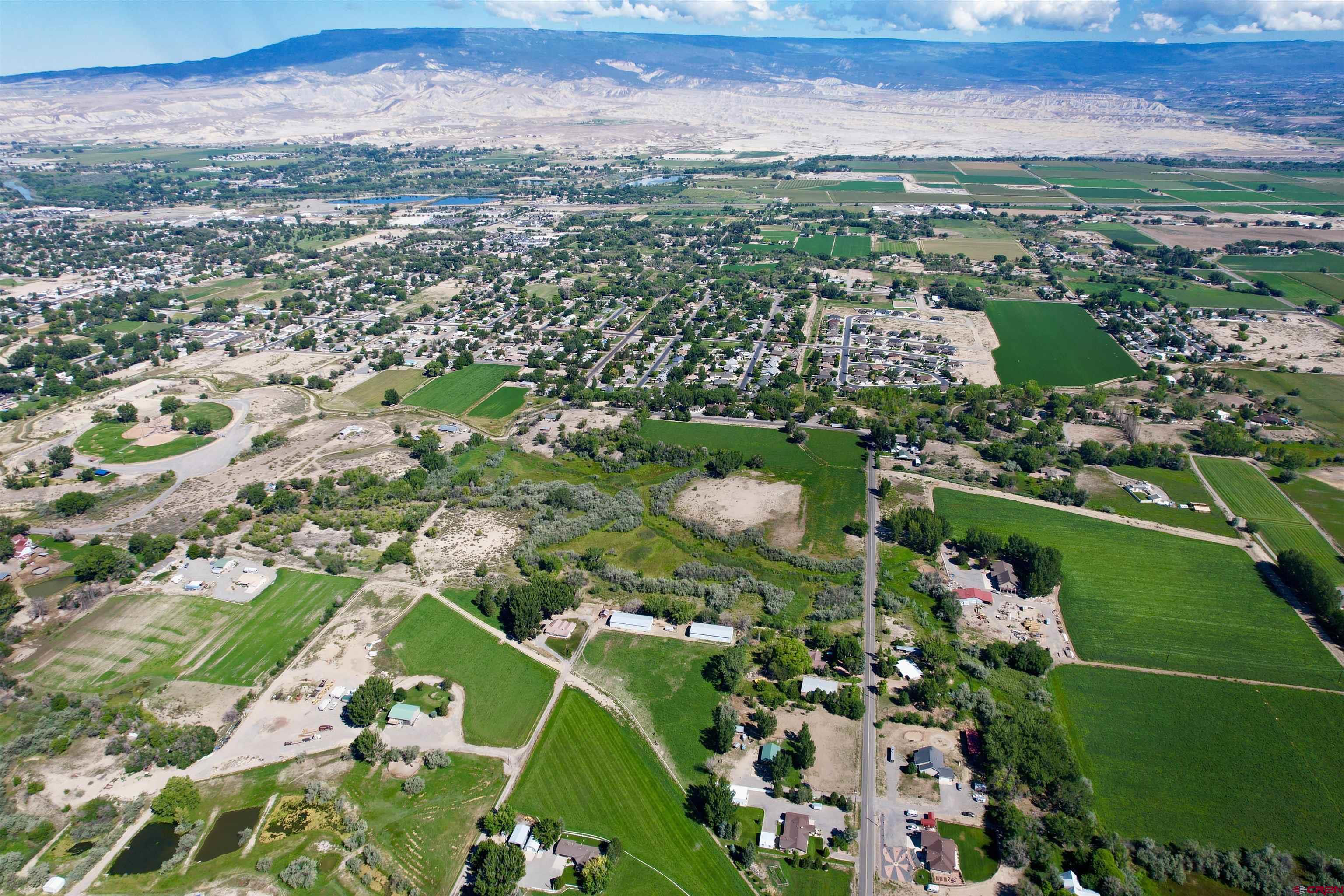 1733 B F Road Delta, CO 81416 - Photo 8 of 24 an aerial view of a houses with a lush green hillside