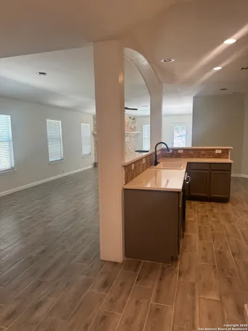 a room with granite countertop a sink and a stove top oven