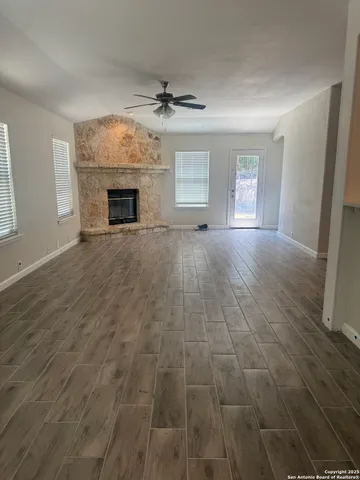 an empty room with windows and fireplace