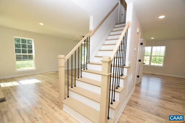 a view of a hallway with wooden floor and windows
