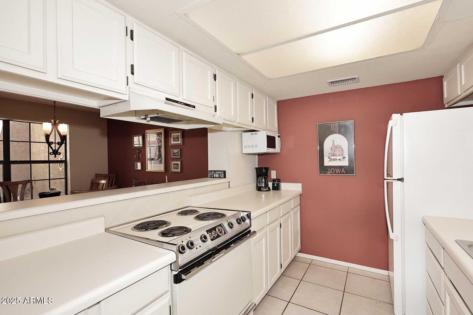 6945 East Cochise Road, Unit 117 Paradise Valley, AZ 85253 - Photo 5 of 39 a kitchen with a stove and a refrigerator