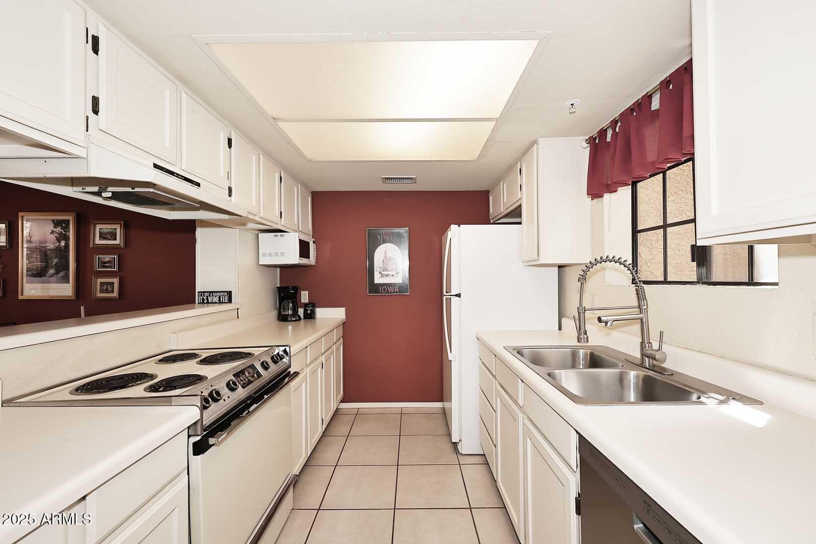 6945 East Cochise Road, Unit 117 Paradise Valley, AZ 85253 - Photo 6 of 39 a kitchen with stainless steel appliances granite countertop a sink stove and refrigerator