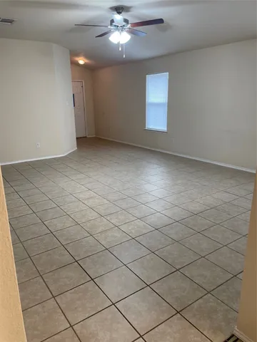 an empty room with windows and ceiling fan