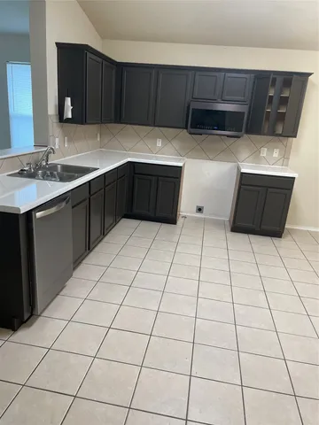 a kitchen with stainless steel appliances a sink dishwasher and cabinets