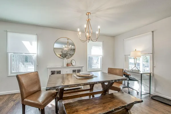 a kitchen with stainless steel appliances granite countertop a sink a stove a refrigerator cabinets and chairs