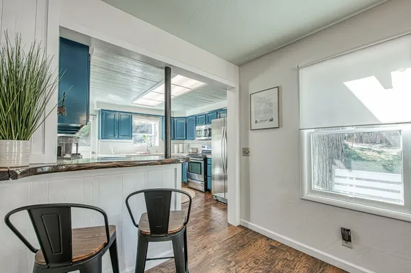 a kitchen with granite countertop wooden cabinets stainless steel appliances and a window