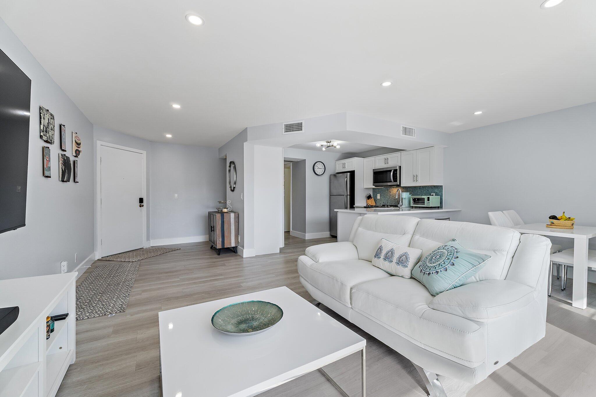 1605 Highway 1, Unit V2204 Jupiter, FL 33477 - Photo 12 of 36 a living room with furniture and wooden floor
