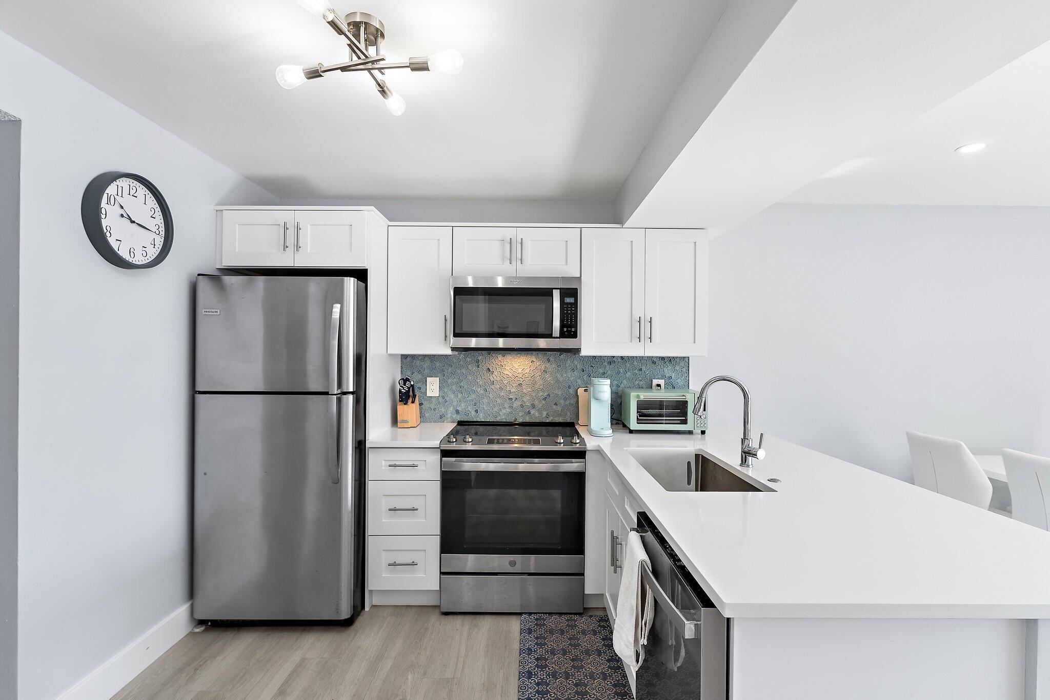 1605 Highway 1, Unit V2204 Jupiter, FL 33477 - Photo 16 of 36 a kitchen with a refrigerator a microwave a sink and cabinets
