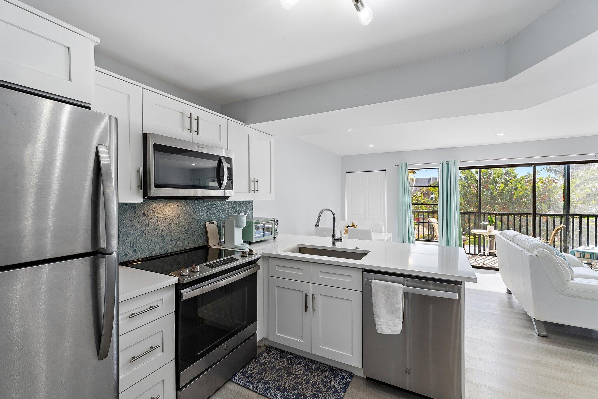 1605 Highway 1, Unit V2204 Jupiter, FL 33477 - Photo 17 of 36 a kitchen with appliances a sink and cabinets