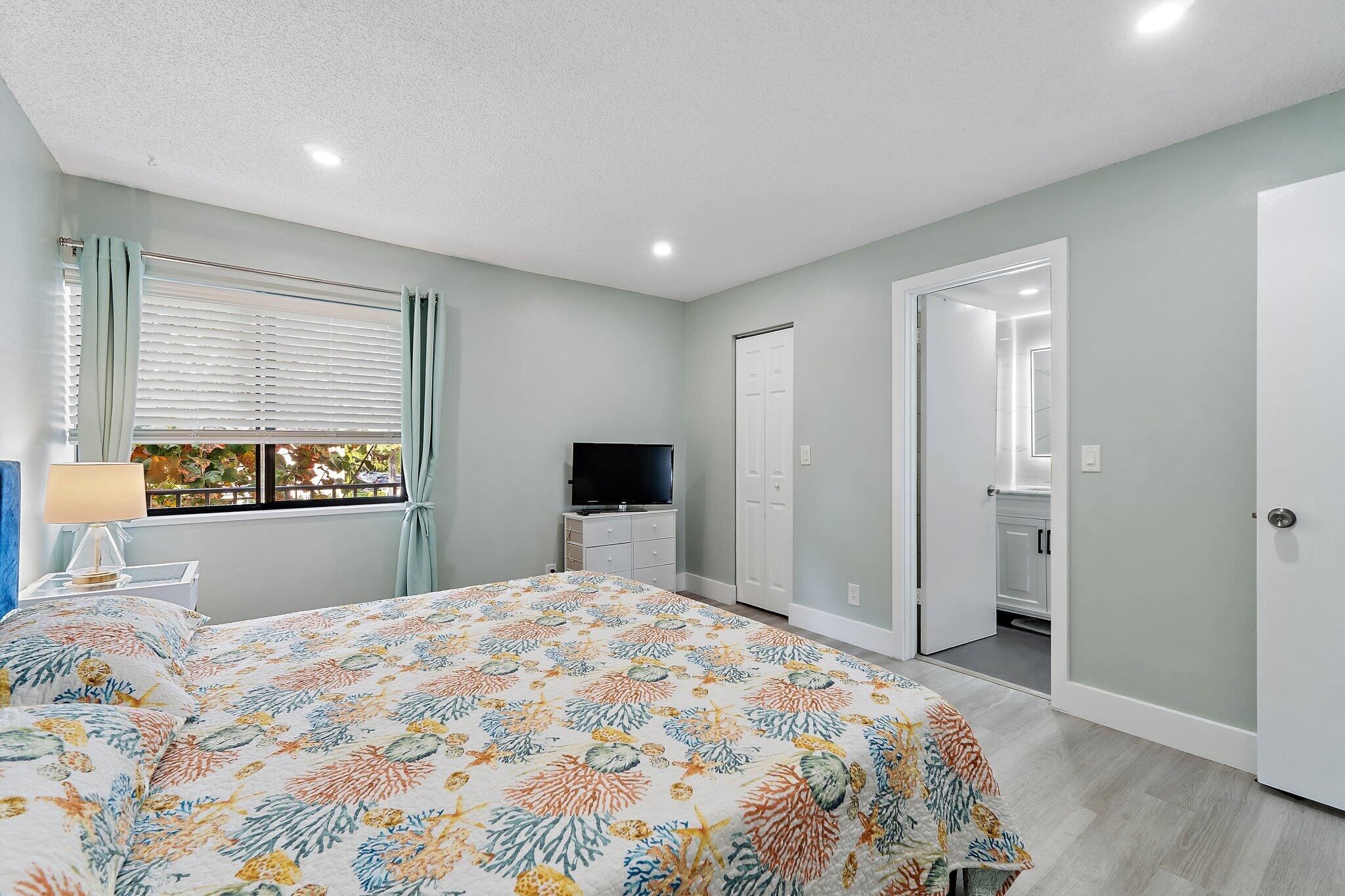 1605 Highway 1, Unit V2204 Jupiter, FL 33477 - Photo 22 of 36 a bedroom with a large bed and a dresser