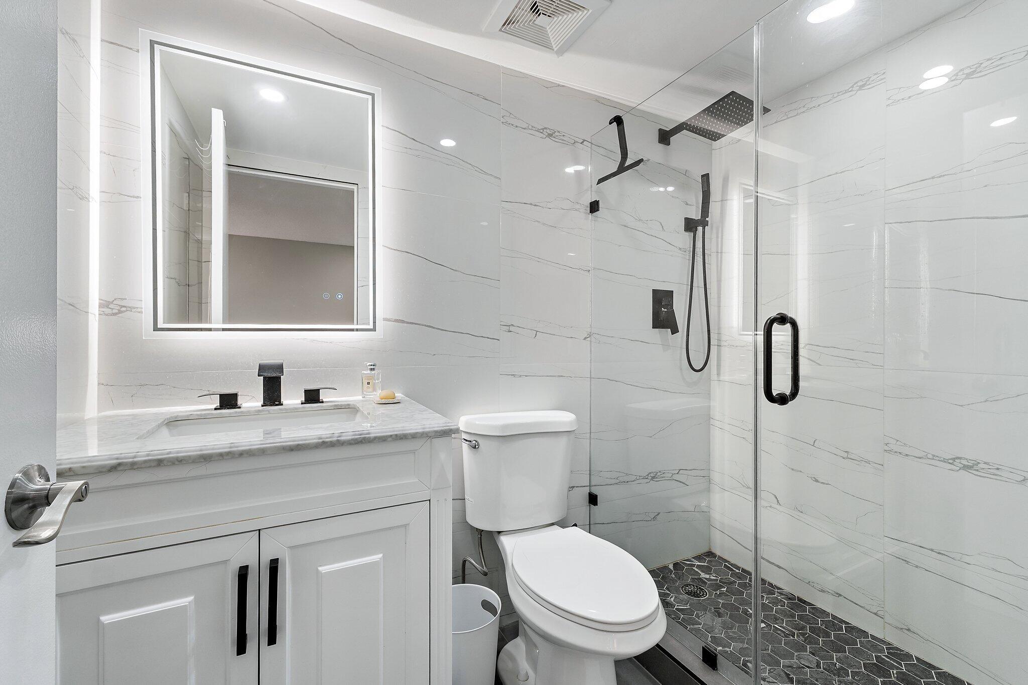1605 Highway 1, Unit V2204 Jupiter, FL 33477 - Photo 25 of 36 a bathroom with a granite countertop sink toilet and shower